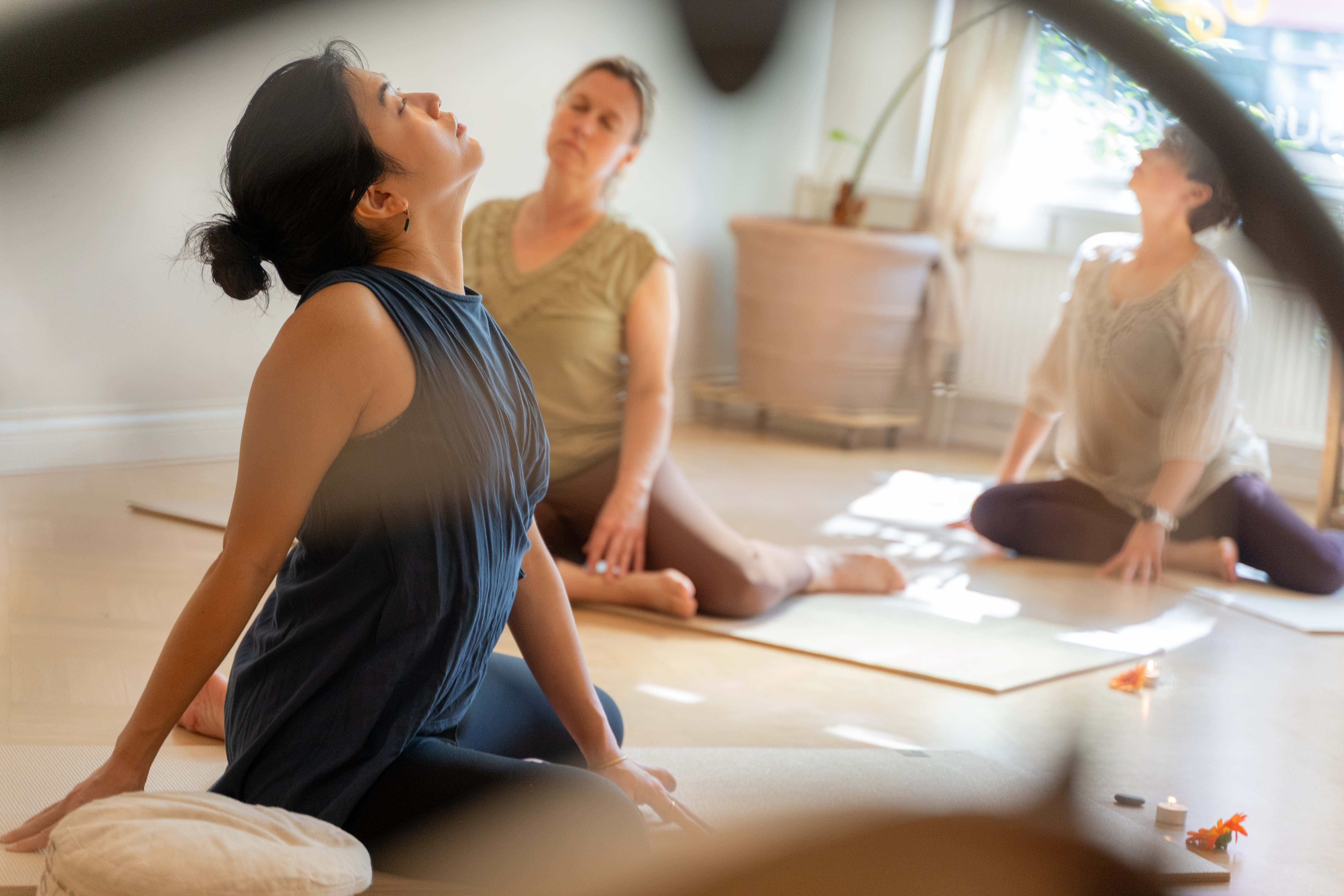 three-women-sitting-on-yoga-mat-moving-softly