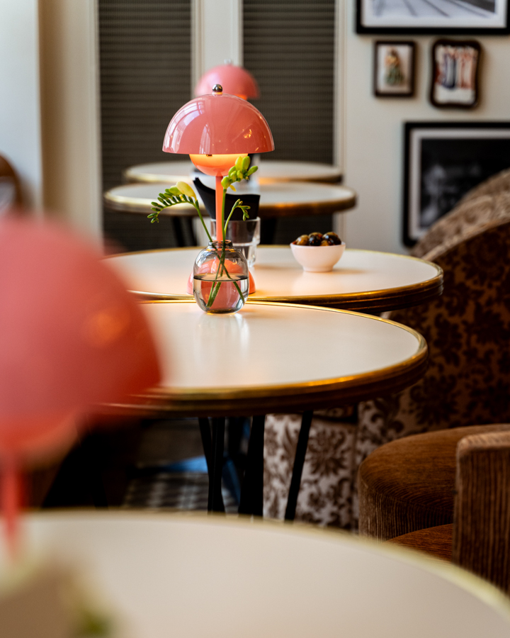 Roze lampen op ronde tafels.