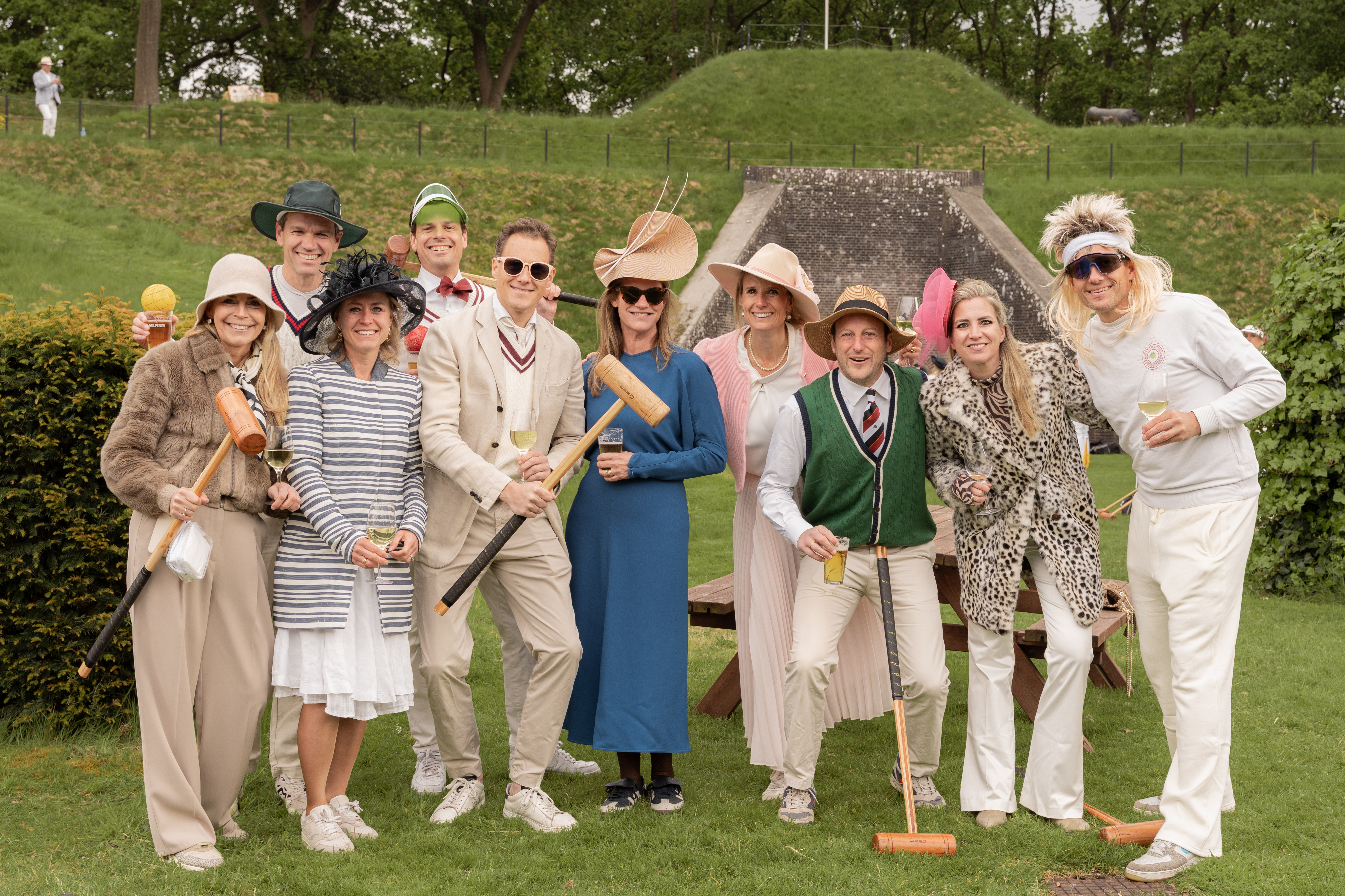 Group of ten people posing for a photo during an croquet event.