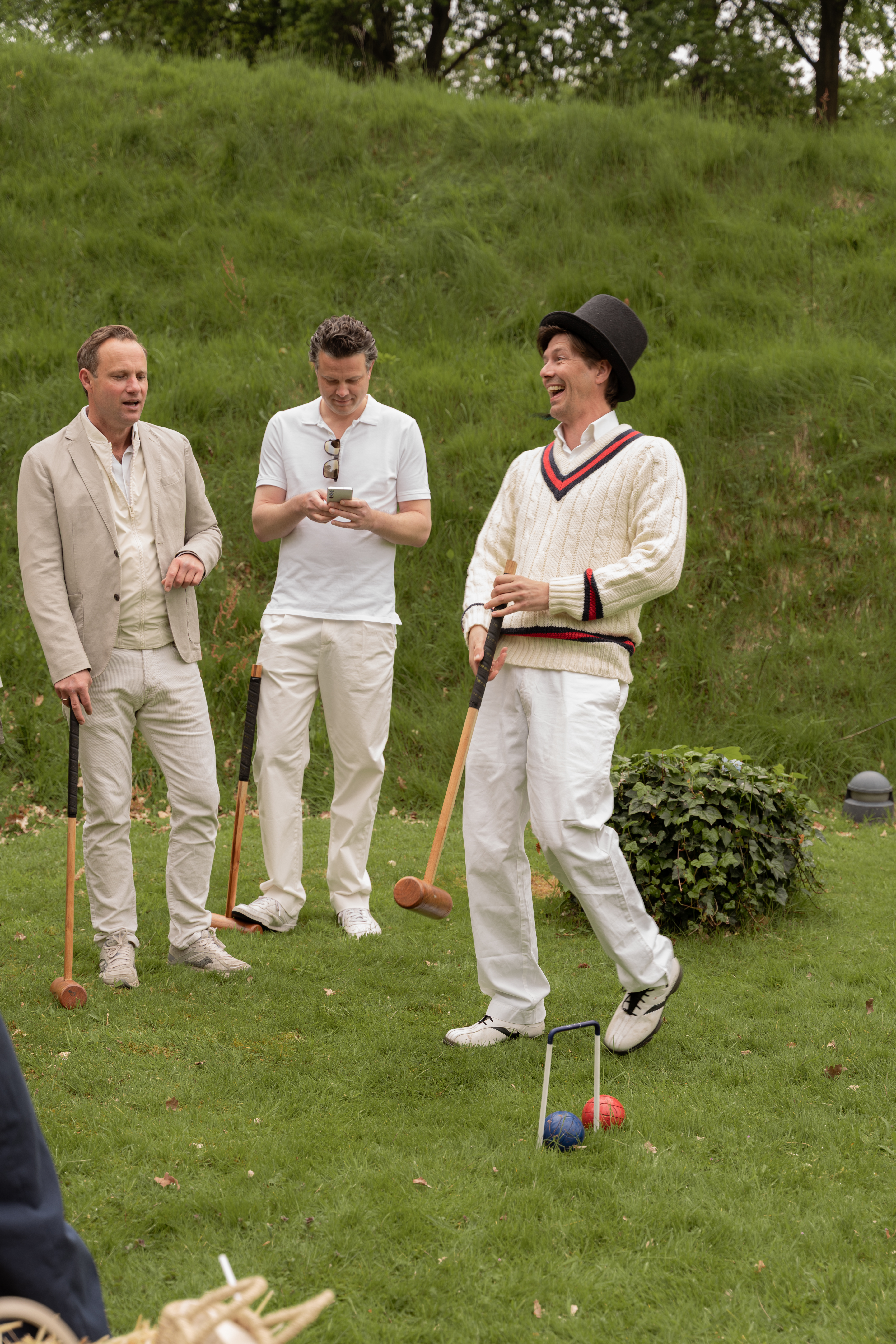 Man laughing while playing croquet.