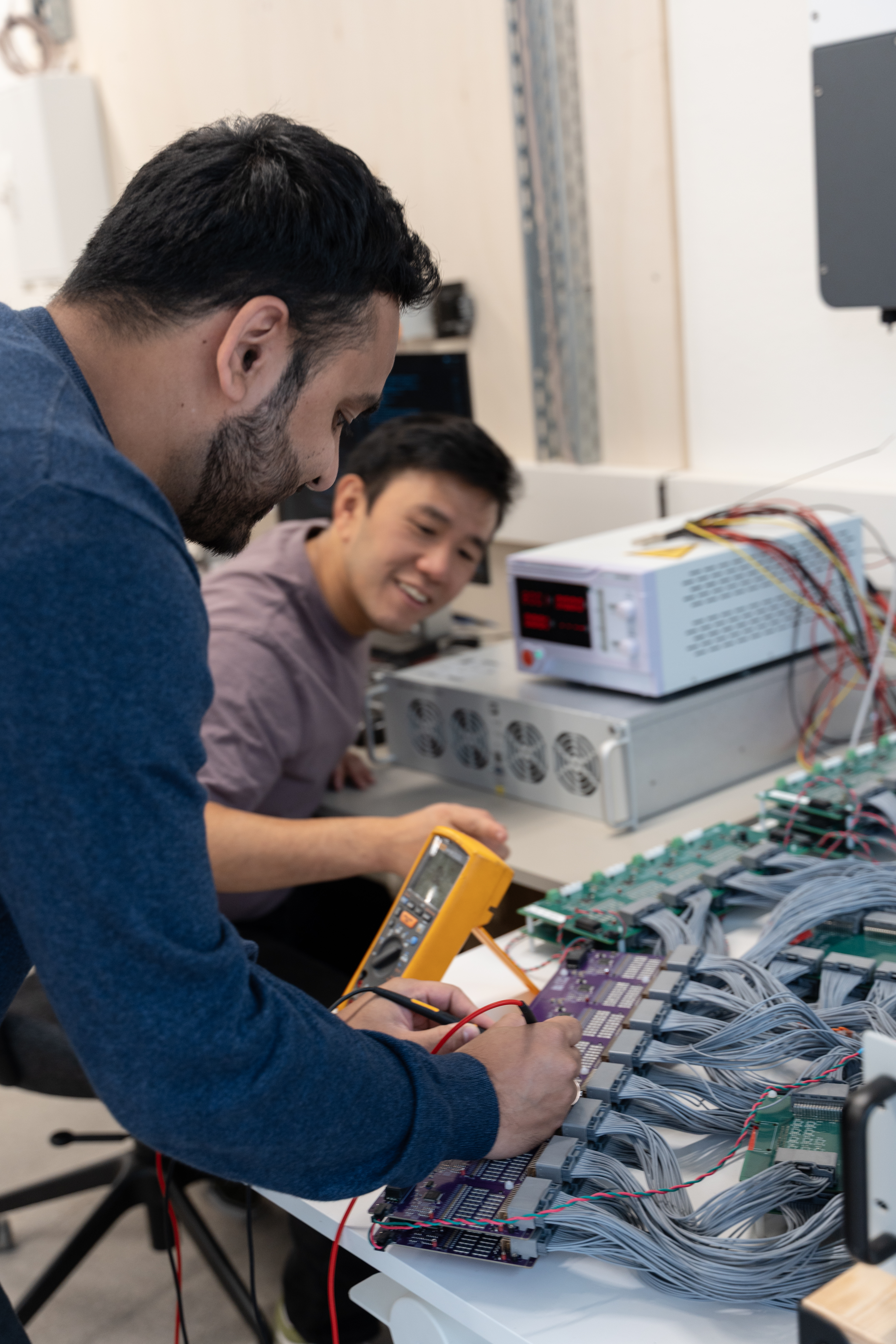 Two men testing electricity device.