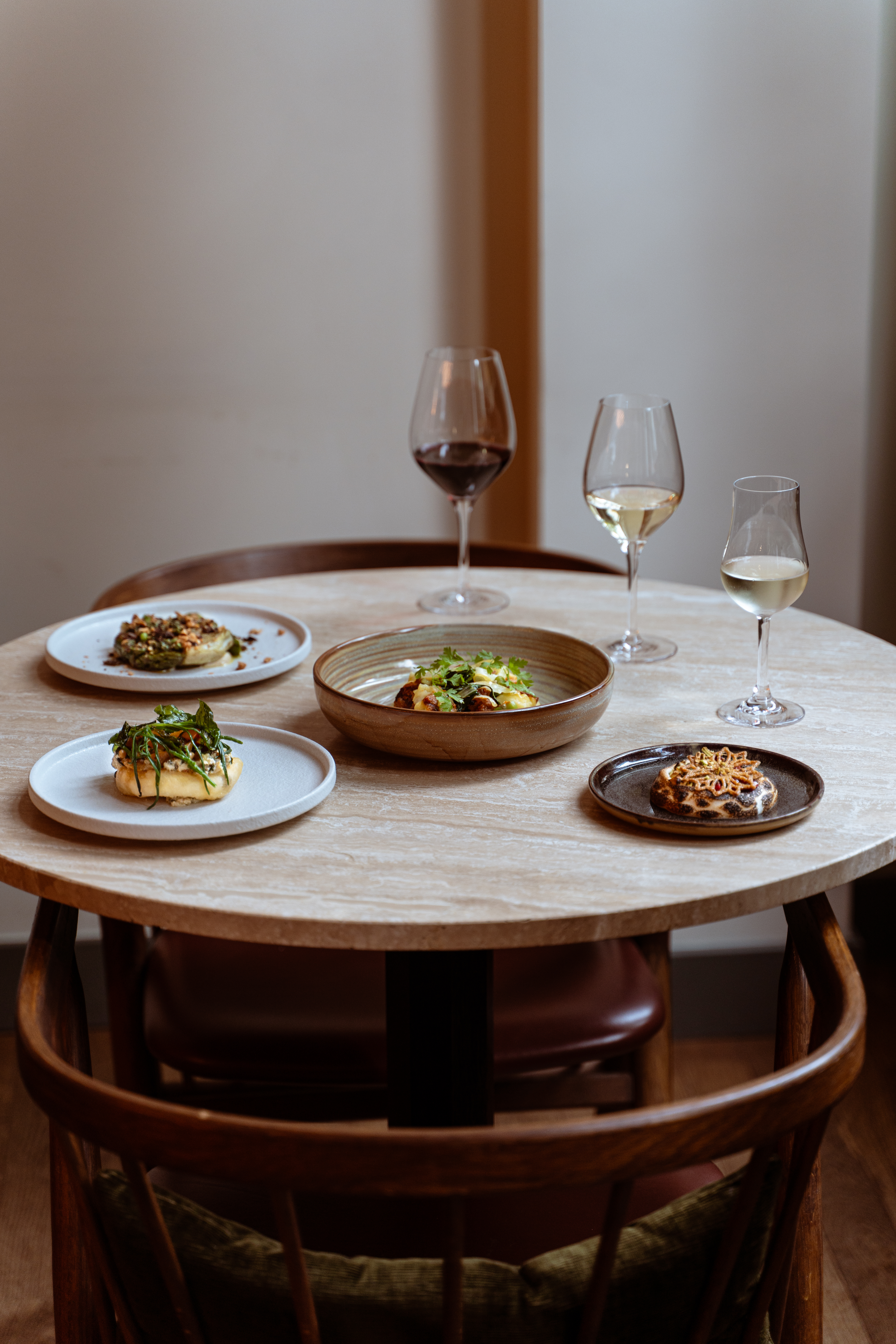 Table in restaurant with different dishes and wines.