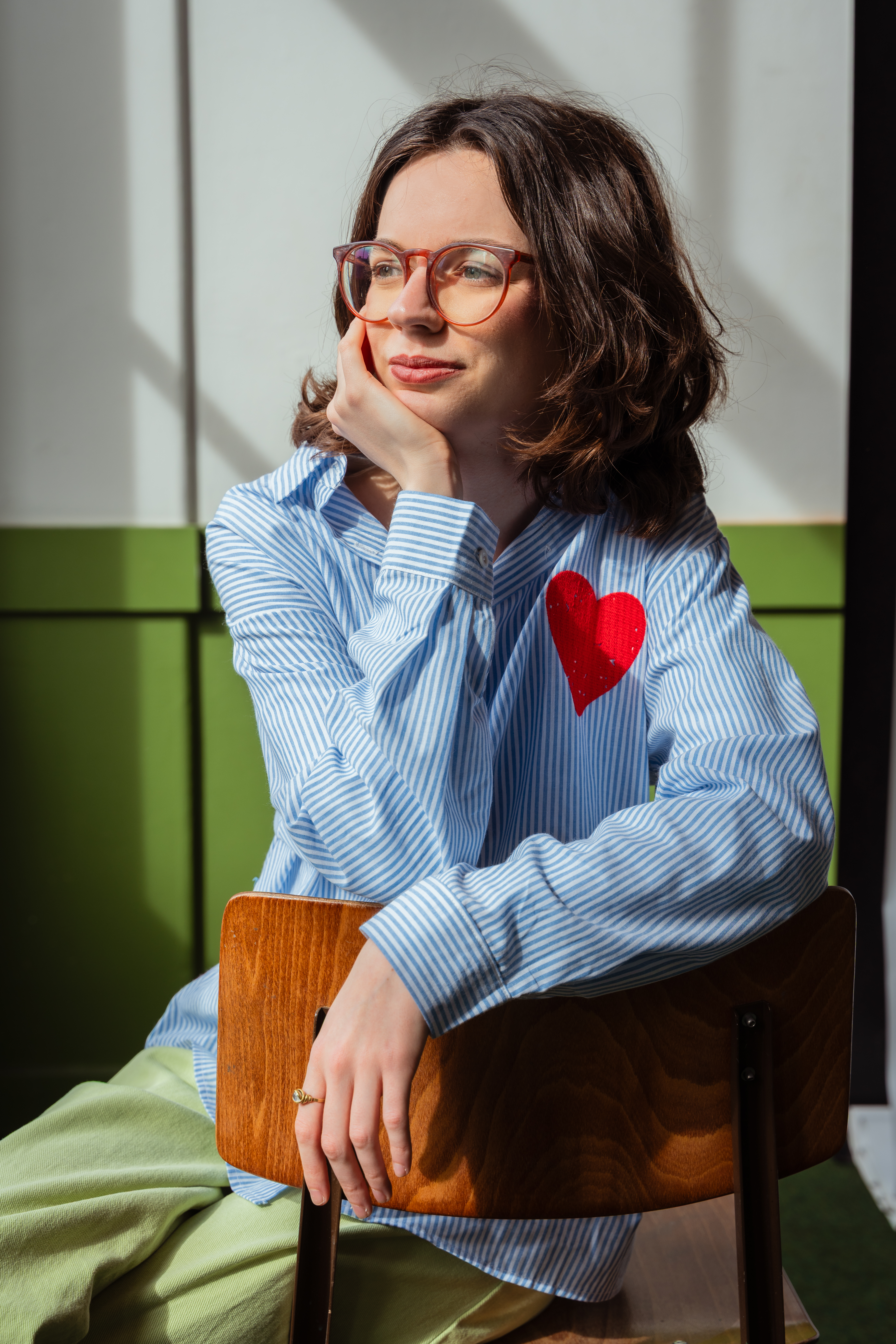 Portrait of woman sitting on chair leaning her head in her hand