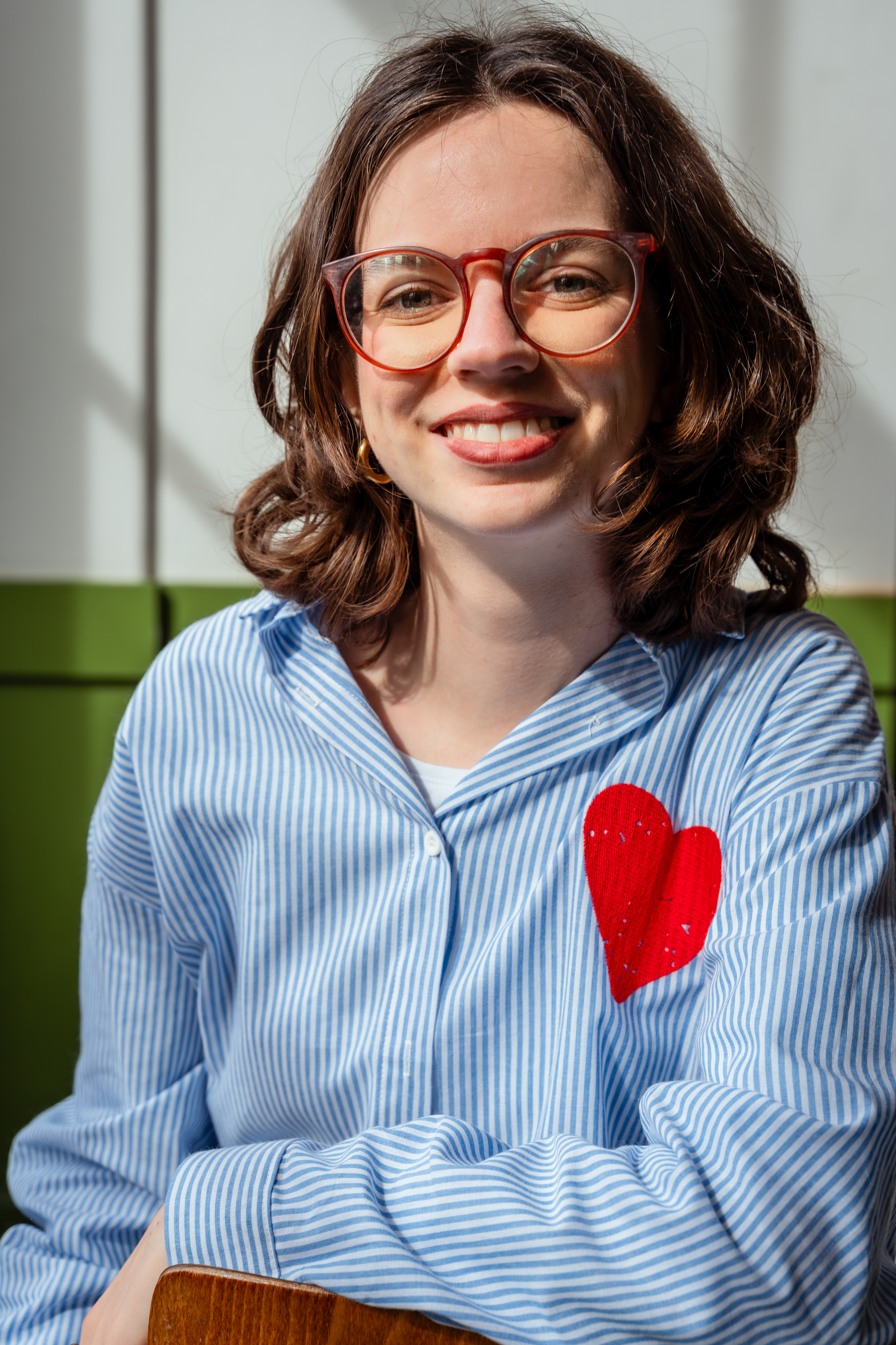 Portrait of woman sitting while looking in camera and smiling
